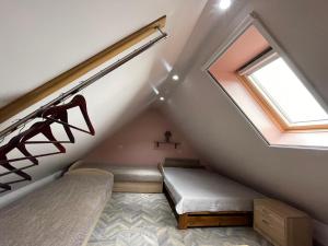 a attic bedroom with a bed and a window at Poilsis Preiloje-91 in Neringa
