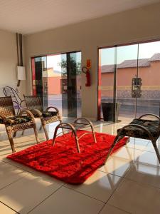 um quarto com cadeiras e um tapete vermelho no chão em Pousada Vidal em Carolina