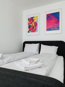 a white bed with two white towels on it at Nordic Style Apartment with Underground parking in Sofia