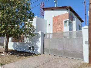 a white house with a fence and a tree at Givarolif in Salta