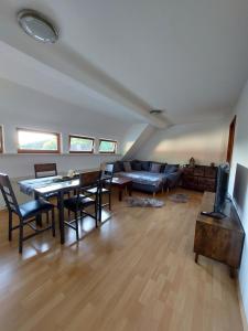 a living room with a couch and a table and chairs at Gemütliche Ferienwohnung im Harz in Bad Grund