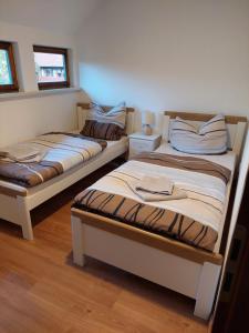 two twin beds in a room with wooden floors at Gemütliche Ferienwohnung im Harz in Bad Grund