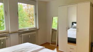 a bedroom with a bed and two windows at Apartment Kaltenbrunn Serviced Apt mit Seeblick am Tegernsee Business & Long Stay only in Gmund am Tegernsee