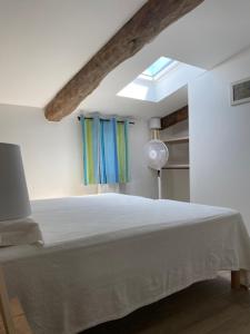 una camera con un letto bianco e una finestra di Location de gîte - Mas catalan (66) a Camélas
