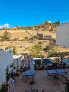 a patio with tables and umbrellas and a hill at Palais Nazha Fes - Luxury Lodging in Fez