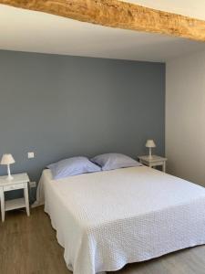 um quarto com uma cama branca e duas mesas em Location de gîte - Mas catalan (66) em Camélas