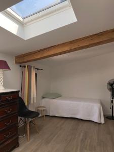 a bedroom with a bed and a skylight at Location de gîte - Mas catalan (66) in Camélas