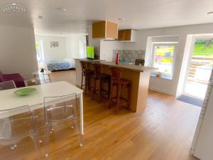 a kitchen and living room with a table and chairs at Gîte du cerisier in Raddon-et-Chapendu