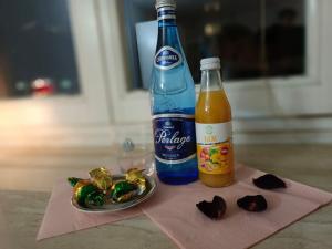 a bottle of soda next to a plate of food at SilverSky Apartment in Warsaw