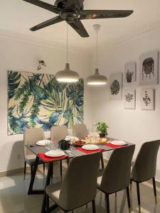 a dining room with a table with chairs and a ceiling fan at Setia Alam @ SCCC 3 Storey House in Shah Alam