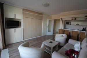 sala de estar con muebles blancos y cocina en Haus Norderhoog Wohnung 54, en Westerland