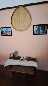 a table in a room with pictures on the wall at Sala Thongyon - Guest House in Savannakhet