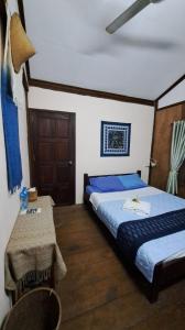 um quarto de hotel com duas camas e uma mesa em Sala Thongyon - Guest House em Savannakhet