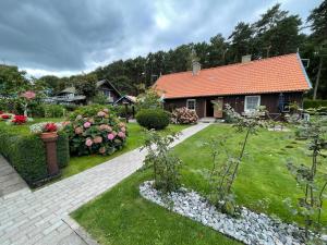 a house with a garden with flowers and plants at Poilsis Preiloje-91 in Neringa