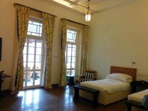 a bedroom with a bed and a large window at The Harrington Residency in Kolkata