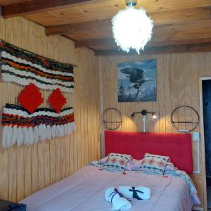 sypialnia z łóżkiem z czerwoną głowicą w obiekcie Hostal Newen w mieście Villarrica