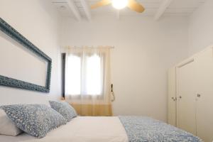1 dormitorio con cama con espejo y ventana en Lavender farm house, en Nafpaktos