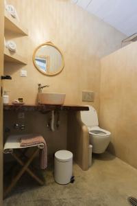 a bathroom with a sink and a toilet and a mirror at Lavender farm house in Nafpaktos