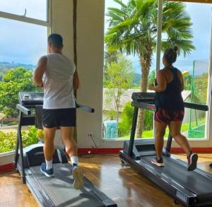 a man and two women on treadmills in a gym at Paraty Hotel Fazenda & Spa in Ibiúna