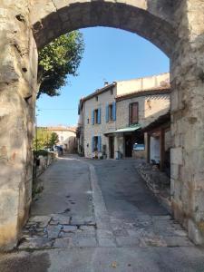 an archway over a street in an old town at Maison de caractère face à l abbaye de lagrasse in Lagrasse