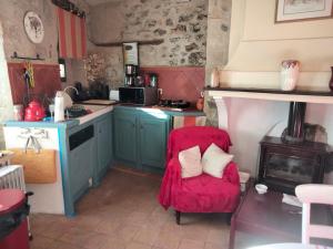 cocina con silla roja y fogones en Maison de caractère face à l abbaye de lagrasse, en Lagrasse