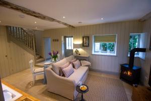 a living room with a couch and a wood stove at The Potting Shed, 5* Luxury escape Cirencester in Cirencester