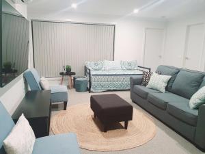 a living room with blue couches and a stool at Tranquility in Lakes Entrance