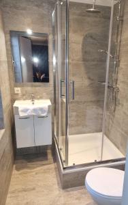 uma casa de banho com um chuveiro, um lavatório e um WC. em Hotel Café de Sport em Velden