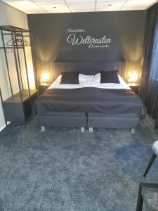 1 dormitorio con 1 cama con un cartel en la pared en Hotel Café de Sport, en Velden