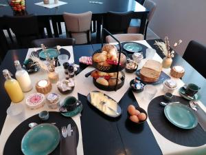 een tafel met eten en borden bij Hotel Café de Sport in Velden