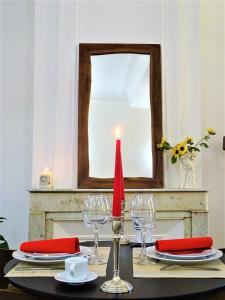a table with a red candle and a mirror at BLUE FOUNTAIN Luxueux Studio Aix Centre Historique -WIFI-SMART TV- in Aix-en-Provence