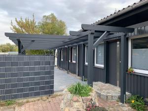 eine schwarze Pergola an der Seite eines Hauses in der Unterkunft Tollenseheim in Neubrandenburg