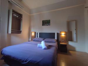 a bedroom with two beds with blue sheets and two lights at Step-in Lodge in Kota Kinabalu