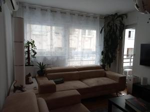 a living room with a couch and a large window at GO 2 Apartment in Belgrade