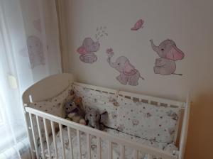 a baby crib with elephants and butterflies on the wall at GO 2 Apartment in Belgrade