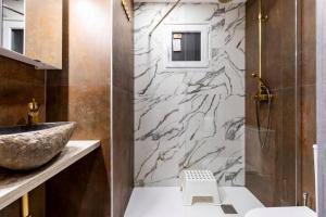 a bathroom with a sink and a marble wall at Apartamento en planta baja en badalona, barcelona in Badalona