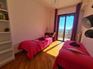 two beds in a room with a large window at Casa Erica by PortofinoVacanze in Rapallo