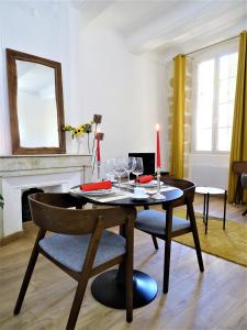 une salle à manger avec une table, une bougie et des chaises dans l'établissement BLUE FOUNTAIN Luxueux Studio Aix Centre Historique -WIFI-SMART TV-, à Aix-en-Provence
