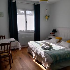 - une chambre avec 2 lits et une fenêtre dans l'établissement Chambres d'hôtes couleur bassin d'Arcachon, à Andernos-les-Bains