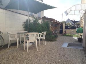 a table and chairs and an umbrella on a patio at Aulnay cocoon in Aulnay-sous-Bois