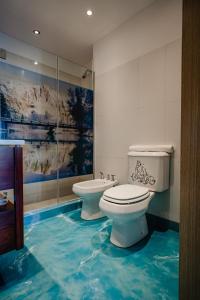 a bathroom with two toilets and a blue floor at Shoshana Hotel Boutique in Buenos Aires