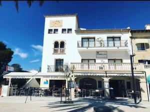 un gran edificio blanco con un reloj encima en Apartamentos Torre Playa en Puerto Pollensa