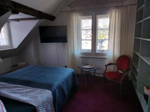 um quarto com uma cama, uma cadeira e janelas em Alte Rentei em Schleiden