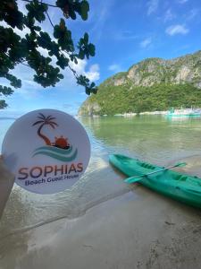 a sign on a beach with a kayak on it at Sophias Beach Guest House in El Nido