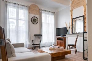 een woonkamer met een bank en een tv bij Magnolia magnifique T2 entièrement rénové. in Montauban
