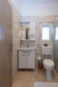 a bathroom with a toilet and a sink and a mirror at Apartman Tribunj in Tribunj