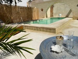 une terrasse avec une table et une piscine dans l'établissement Palazzo Giustiniani L'Ambasciatore, à Sogliano Cavour