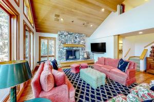 a living room with pink furniture and a stone fireplace at Baldy View Lodge in Ketchum