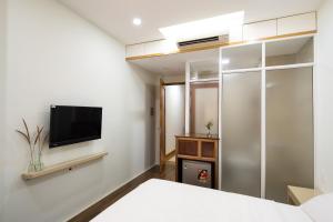 a bedroom with a bed and a tv on a wall at Homestay TITO in Ho Chi Minh City