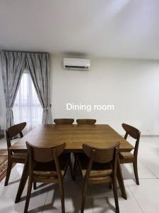 uma sala de jantar com uma mesa de madeira e cadeiras em Homestay Damansara 2BD 2Parking em Petaling Jaya